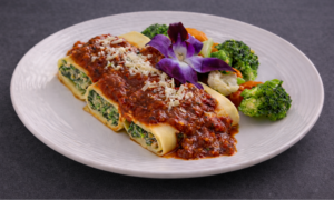 Eggplant and ricotta cannelloni with marinara sauce plated for vegetarian catering